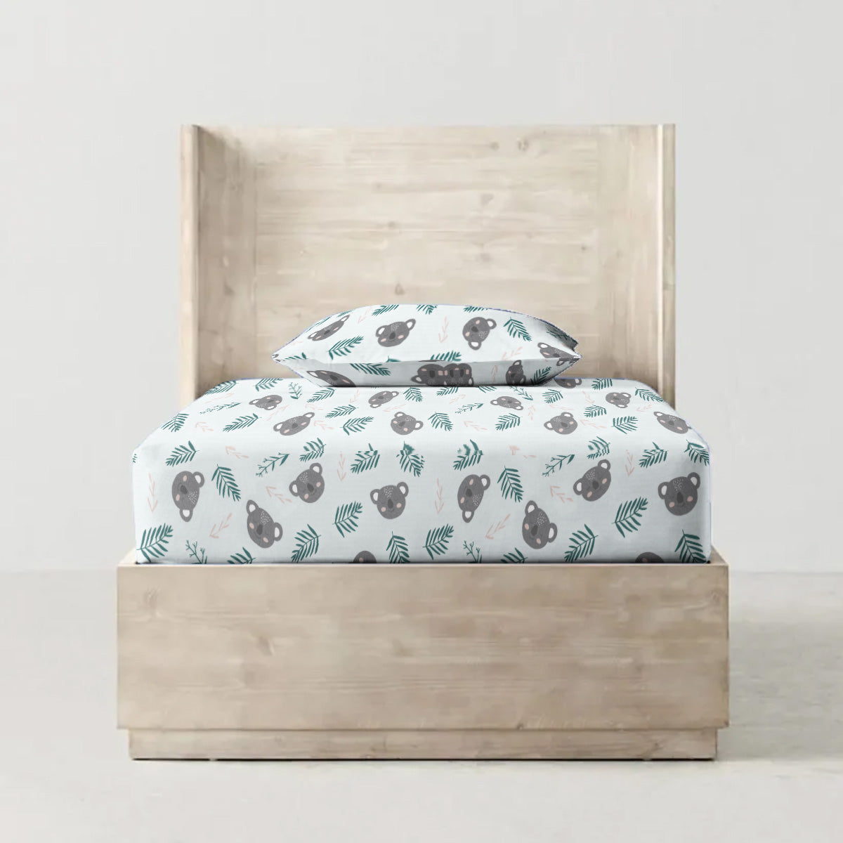 Children's bed with patterned bedding and headboard on a plain background