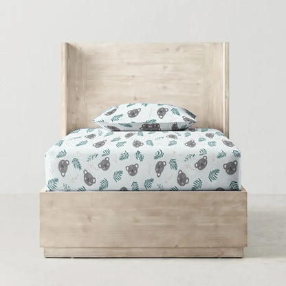 Children's bed with patterned bedding and headboard on a plain background