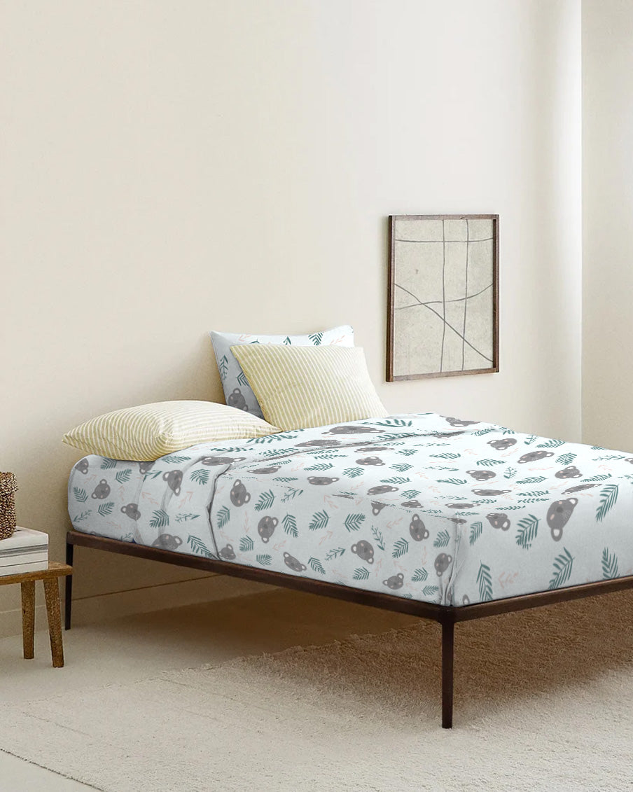 Bed with floral-patterned bedding in a minimalistic room.