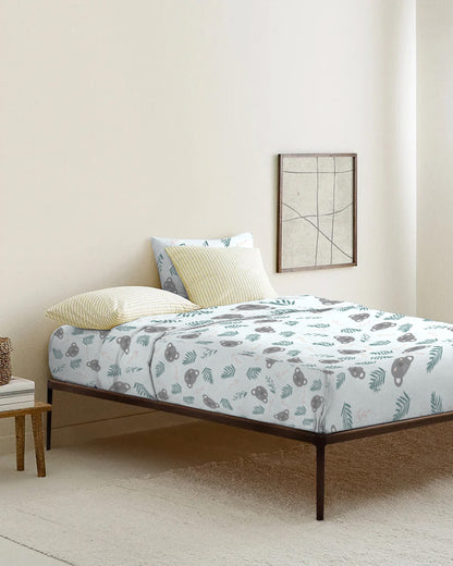 Bed with floral-patterned bedding in a minimalistic room.