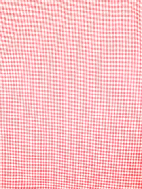 Close-up of pink fabric with a subtle check pattern