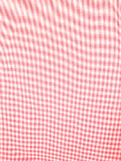 Close-up of pink fabric with a subtle check pattern