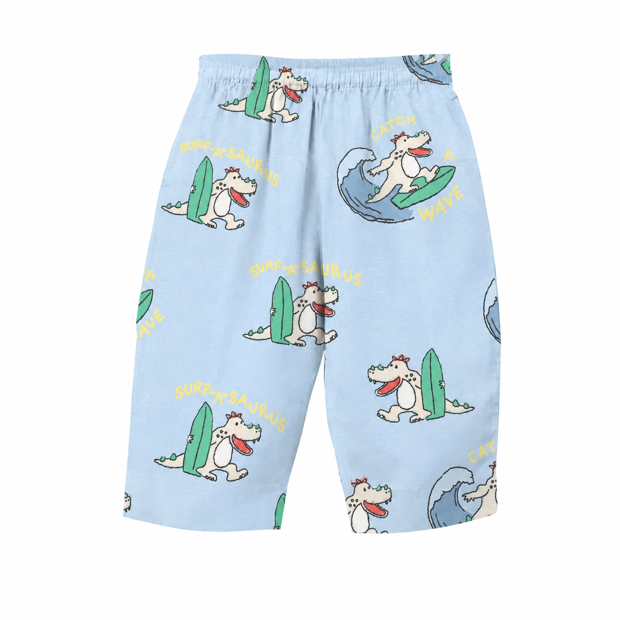 Light blue shorts with an all-over cartoon dinosaur surfing pattern, featuring yellow text and green surfboards, shown against a plain white background.