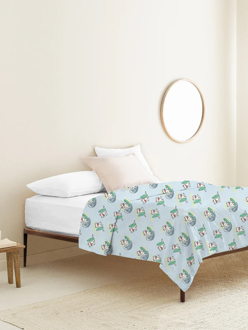 Bed with a light blue comforter featuring cartoon characters in a bedroom setting.