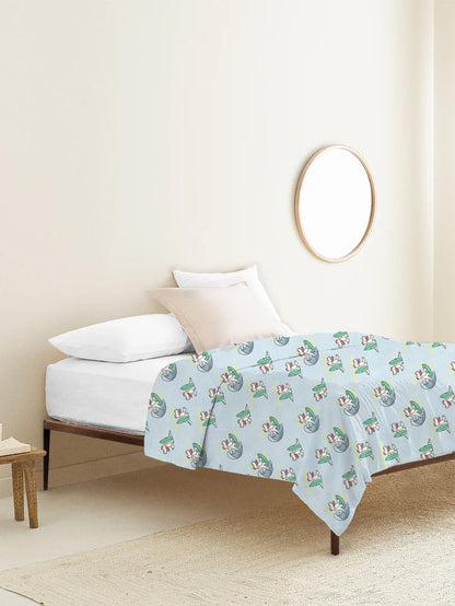 Bed with a light blue comforter featuring cartoon characters in a bedroom setting.