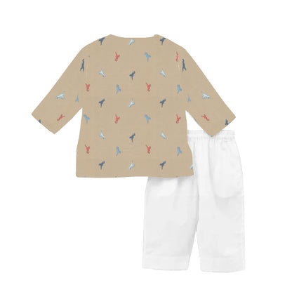 Children's outfit with a beige patterned top and white pants on a white background